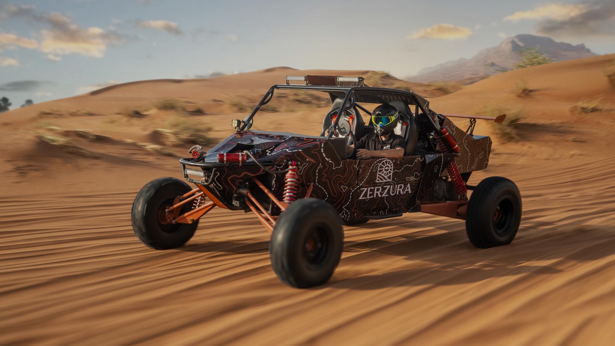 Driver riding dune buggy across golden sand dunes in Mleiha desert
