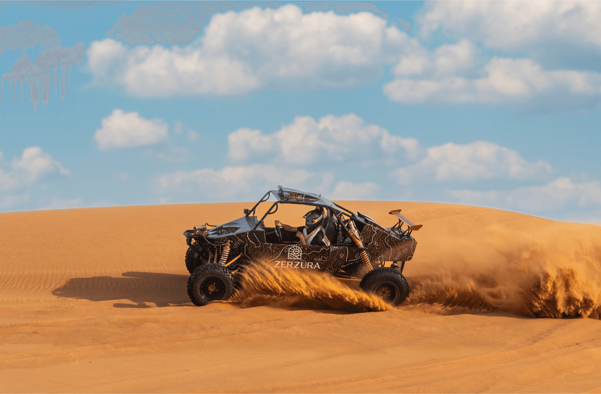 Guest driving dune buggy in Mleiha desert during Zerzura’s luxury Abu Dhabi desert safari